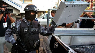 A police officer loads radio equipment on a police vehicle after the closure of the Globo radio station in Tegucigalpa, Monday, Sept. 28, 2009. 