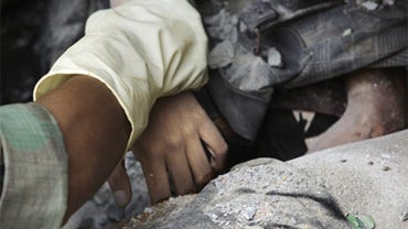 An Indonesian rescue worker pulls the hand of a victim as they try to remove bodies trapped in a collapsed building Saturday, Oct. 3, 2009 in the Sumatran Island city of Padang, Indonesia, three days after Wednesday's 7.6-magnitude quake that toppled thou 