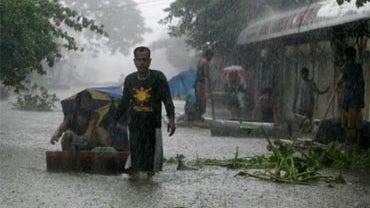 Residents go on their daily business amidst floodwaters at Angono township, Rizal province east of Manila, Philippines Saturday Oct. 3, 2009. 