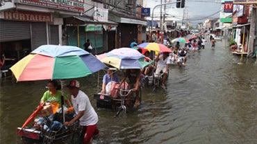 Residents go on their daily business amidst flooding as Santa Cruz township remains flooded for more than a week Sunday Oct. 4, 2009 in Laguna Lake south of Manila, Philippines. 