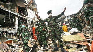 An Indonesian soldier orders reporters to move away at the ruins of Ambacang Hotel that was destroyed by last week's earthquake in Padang, West Sumatra, Indonesia 