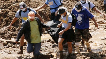 Rescuers carry a body bag of a landslide victims they recovered Saturday, Oct. 10, 2009 in La Trinidad, Benguet province, north of Manila, Philippines after a mountainslide swept away dozens of houses at the height of typhoon Parma. 