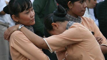 A hotel worker leans on her colleague as they are evacuated outside their building after a preliminary magnitude 6.4 earthquake was felt in Jakarta 