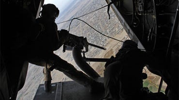 United States Marine Cpl. Jeremiah Judd of Hawaii, scans the ground below for insurgents with a 50 calibre machine gun from the back of a Marine Osprey aircraft as they fly over Lashkar Gah, in the volatile Helmand Province of Southern Afghanistan, Thursd 