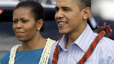 President Barack Obama and first lady Michelle Obama, both wearing a leis, walk over to the crowd at Hickam Air Force Base in Honolulu Thursday, Dec. 24, 2009. They are in Hawaii for the holidays. 