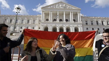 Helena Paixao, center left, and Teresa Pires toast with champagne outside the Portuguese parliament, Friday, Jan. 8 2010, in Lisbon after lawmakers passed a bill allowing gay marriage. 