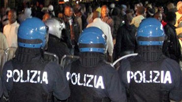 In this photo taken Jan. 7, 2010 made available Friday Jan. 8 2010, Italian police officers in riot gear are seen engaging a group of immigrant workers in the streets Rosarno, near Reggio Calabria, southern Italy. Hundreds of immigrant workers rioted thro 