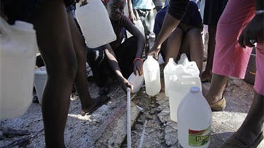 Girls collect water from a broken pipe in the ground to take back to their families who are camped in vacant lots in Port au Prince, Friday, Jan. 15, 2010. A powerful earthquake hit Haiti Tuesday. (AP Photo/Julie Jacobson) 