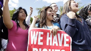 From left to right, protesters Jennifer Luna, Jakleline Castro, and Mayvi Garcia, all of Phoenix, shout during a rally after the signing of immigration bill SB1070 into law by Gov. Jan Brewer Friday, April 23, 2010, in Phoenix. The sweeping measure would  