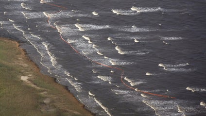 Oil booms that were placed in preparation of the looming oil spill from last week's collapse and oil spill from the Deepwater Horizon oil rig are strewn along the shoreline by choppy seas in Port Eads, La. on Thursday, April 29, 2010. 