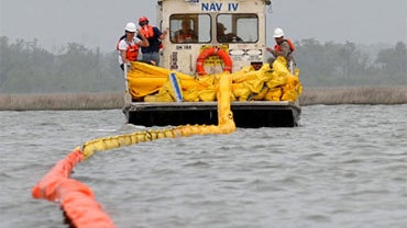 Work crews with Ashland Cleaning Services lay oil retention booms in Bay St. Louis, Miss., Saturday, May 1, 2010.  