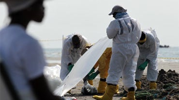 Workers clean up oil residue along the beach in Port Fourchon, La., Saturday, May 29, 2010. 