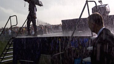President Barack Obama walks off stage in the rain after urging the crowd to go to their cars, Monday, June 31, 2010, during a Memorial Day ceremony at Abraham Lincoln National Cemetery in Elwood, Ill., Monday, May 31, 2010. 