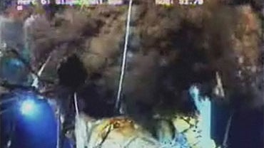 An underwater camera captures oil and gas at the site of the capped well head in the Gulf of Mexico, Monday, June 7, 2010. Engineers are working to close the vents on the cap. 