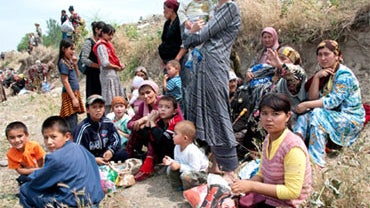 Ethnic Uzbeks gather near the Kyrgyz-Uzbek border in southern Kyrgyzstan, on Saturday, June 12, 2010, trying to seek refuge in Uzbekistan from mobs of Kyrgyz men attacking the minority Uzbek community. 
