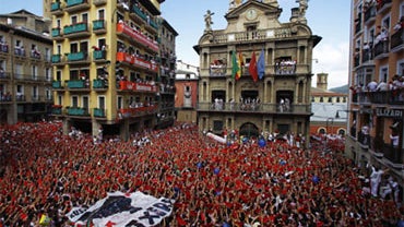 Revelers hold up traditional red neckties during the "Chupinazo," the official opening of the 2010 San Fermin fiestas, on Tuesday, July 6, 2010 in Pamplona, Spain.  