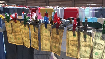 U.S. notes hang on a drying line after been washed in Harare, Zimbabwe, Tuesday, July 6, 2010.  