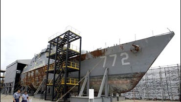 South Korean Navy personnel walk past the wreckage of the 1,200-ton Cheonan that the government claims was sunk by a North Korean torpedo in March, Pyeongtaek, South Korea, July 9, 2010. 