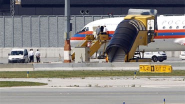 Limousines sit beside a Russian plane believed to be carrying candidates for a 14-person spy swap as part of the largest spy swap since the Cold War, on the tarmac at Vienna's Schwechat airport, Friday, July 9, 2010. 
