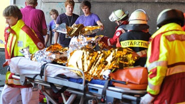 Emergency services personal work the scene after panic broke out in a tunnel during the Loveparade in Duisburg, western Germany, on July 24, 2010.  