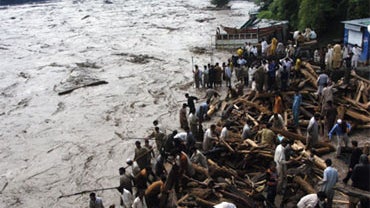 Pakistani residents stand by flood water that entered a residential area of Muzaffarabad on July 30, 2010.  