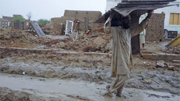 A man carries remains of his house destroyed by heavy floods in Dera Ismail Khan, northwestern Pakistan on Tuesday, Aug. 3, 2010. 