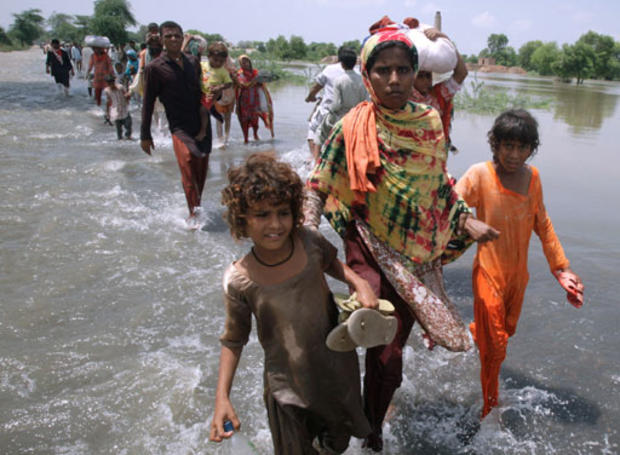 A Pakistani man carries his child and household items through floodwaters in Sujawal in southern Sindh province, August 30, 2010. 