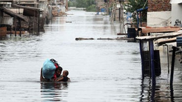 A Pakistani man carries his child and household items through floodwaters in Sujawal in southern Sindh province, August 30, 2010.  