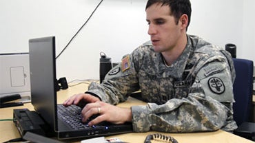 In this April 8, 2010 photo, Capt. Scott Smiley checks e-mail in his office in West Point, N.Y.  