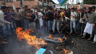 Kashmiri protesters beat the burning remains of an effigy representing US President Barack Obama during a protest in Budgam on the outskirts of Srinagar on September 13, 2010. 