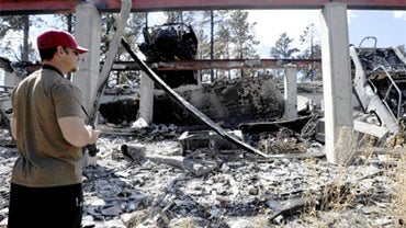 Foster Bailey takes photos of the remains of his home after the Fourmile Canyon fire in Boulder, Colo. on Monday, Sept. 13, 2010. 