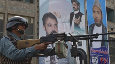 A police officer mans a machine gun on a street corner a day ahead of parliamentary elections in Kabul, Afghanistan, Friday, Sept. 17, 2010.  