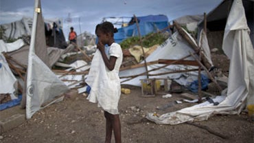 A girl stands next to her tent after it fell down due to heavy rain at a camp for earthquake survivors in Port-au-Prince, Haiti, Saturday, Sept. 25, 2010. 