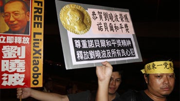 Pro-democracy protesters hold a picture of Chinese dissident Liu Xiaobo and signs reading "Congratulate Liu Xiaobo winning Nobel Peace Prize," and "Respect the spirit of Nobel Peace Prize. Release Liu Xiaobo and all dissidents," during a demonstration out 