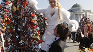 A newly-wedded couple react on their wedding day in downtown Moscow, Russia, Sunday, Oct. 10, 2010. Many Russian couples decided to marry Sunday, the 10th day of the tenth month, 2010. 