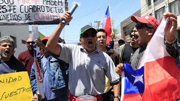 Workers from the San Jose mine protest for back pay and higher salaries in Copiapo, Chile, Tuesday Oct. 19, 2010. The San Jose mine is inoperable following the cave-in that trapped 33 miners for 69 days and its owners have declared bankruptcy. The sign at 