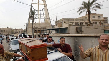 The coffin of a victim is strapped onto a car outside Our Lady of Deliverance church the morning after its congregation was taken hostage in Baghdad, Iraq, Monday Nov. 1, 2010. 