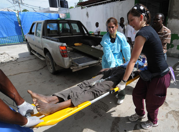 Nurses help a cholera victim into the Hospital 