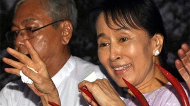 Myanmar's detained opposition leader Aung San Suu Kyi waves to a crowd of supporters gathered outside her house after her release in Yangon on November 13, 2010.  