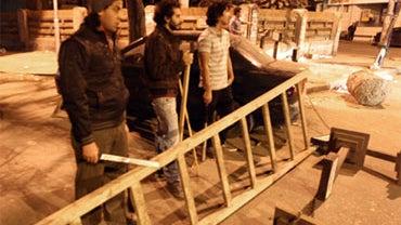 Egyptian civilians carrying batons and sticks stand guard behind barricades in a Cairo street as they protect their properties from looters on January 29, 2011. 