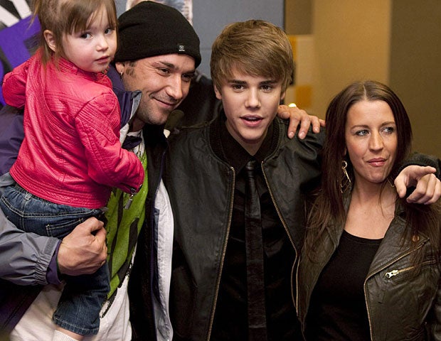 Singer Justin Bieber, center, poses with his mother Pattie Lynn Mallette, right, father Jeremy Bieber and sister Jazmyn prior to the screening of his new film "Justin Bieber: Never Say Never" in Toronto Tuesday, Feb. 1, 2011. (AP Photo/The Canadian Press, 