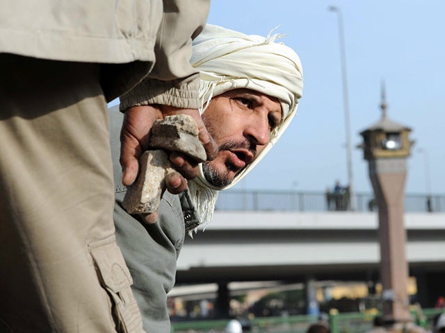 anti-government protester holds stones in his hand 