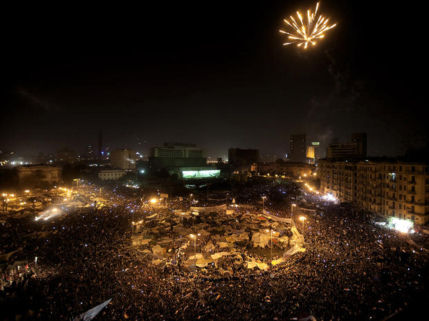 Egyptian anti-government protesters celebrate under fireworks 