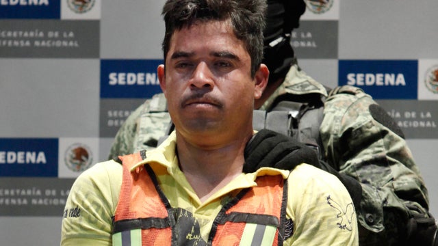 A soldier escorts Julian Zapata Espinosa, aka  