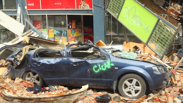A car remains crushed under derbris 