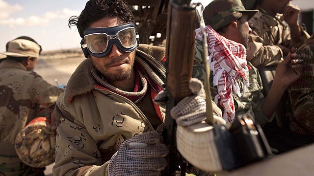 Libyan rebels who are part of the forces against Libyan leader Muammar Qaddafi sit in their vehicle near Ras Lanuf, eastern Libya, March 7, 2011.  