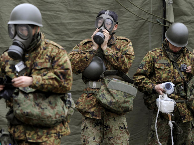 Japanese soldiers mobilize to wash radioactive material from emitted from the Fukushima nuclear power plant on March 15, 2011. 