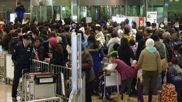 Chinese people crowd at a check-in counter at Niigata airport 