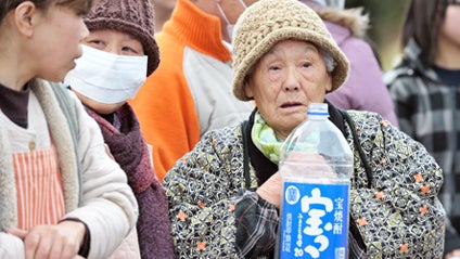 People wait for water distribution in Ofunato on March 16, 2011 