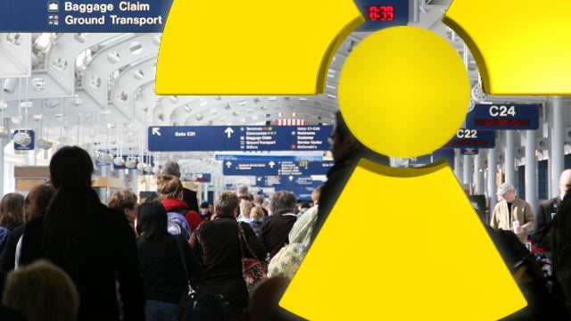 Passengers walking through airport  with radiation symbol 